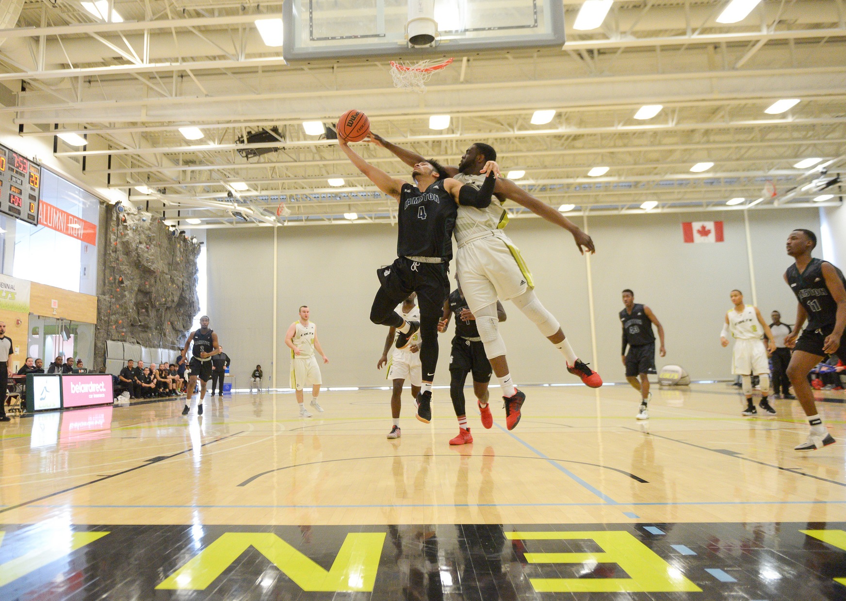 Branden Padgett of the Lambton Lions finishes a reverse layup over the outstretched arms of Walshak Yusef during second quarter action of the crossover playoff match between the two teams at the Athletic and Wellness Centre. Lambton won, 83-74, ending Centennial's season and advancing to the 2018 belairdirect OCAA Championships (Khree Fearman/Colts Athletics).