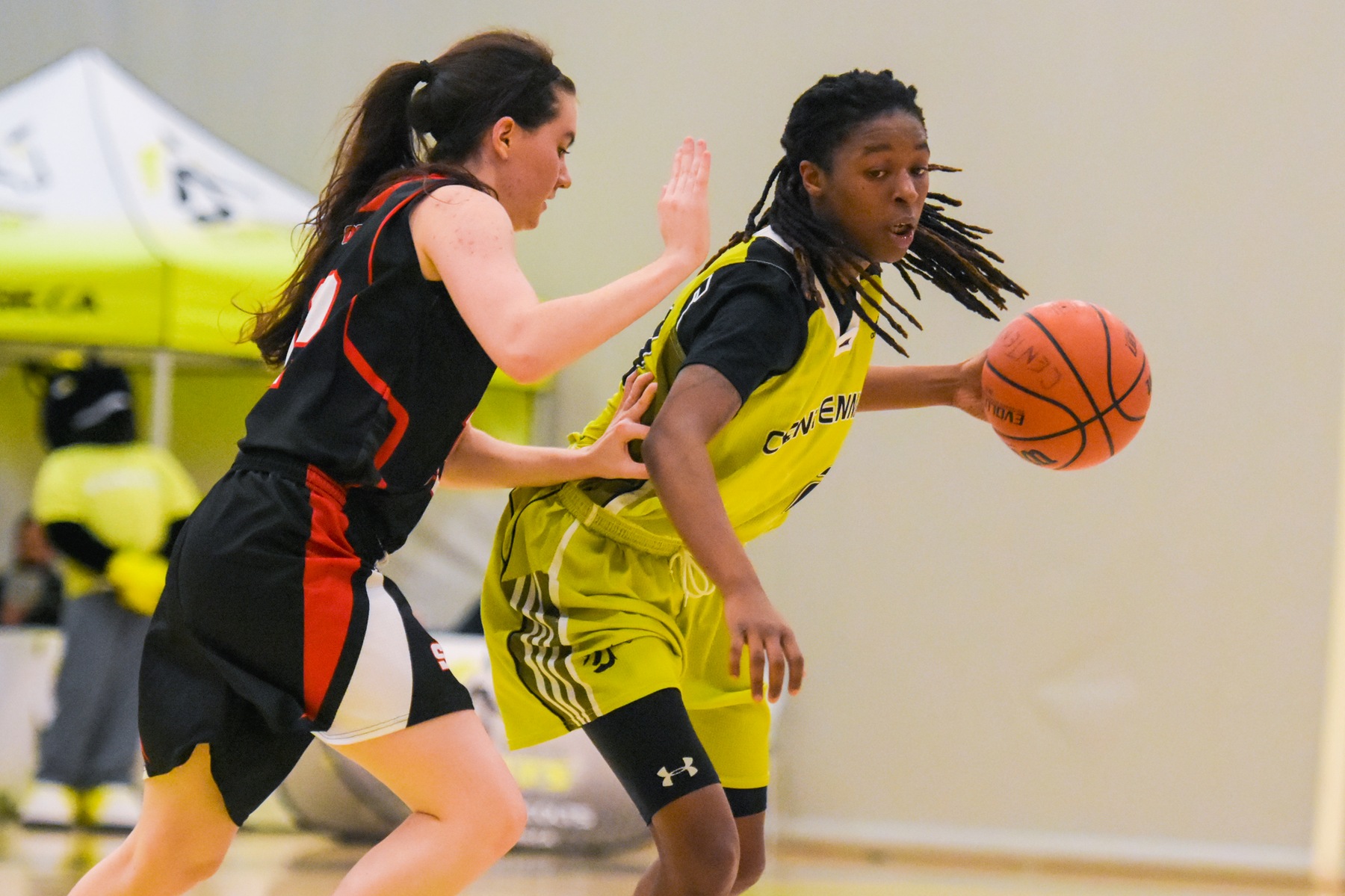 Colts women's basketball player Kayla Higgins bouncing a ball driving to the hoop