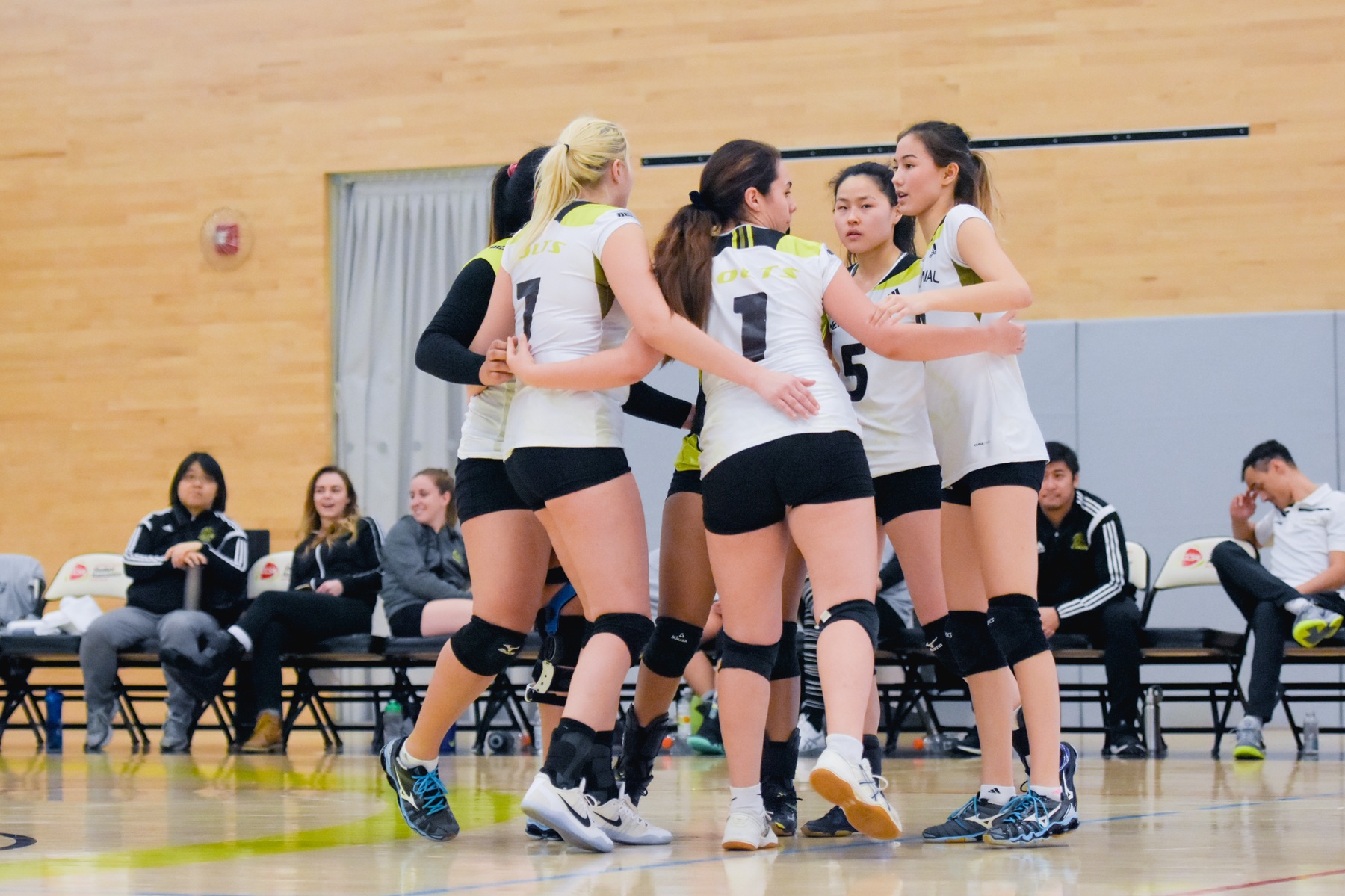 Colts Women's Varsity Volleyball Team in a huddle on the court